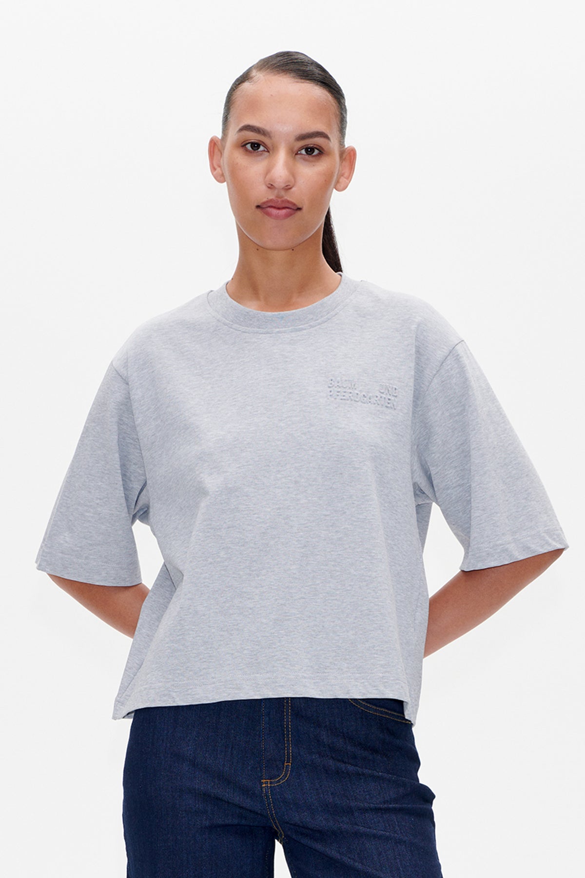 Front detail of a heather-grey short-sleeved crew-neck T-shirt with subtle raised Baum und Pferdgarten lettering on the chest.
