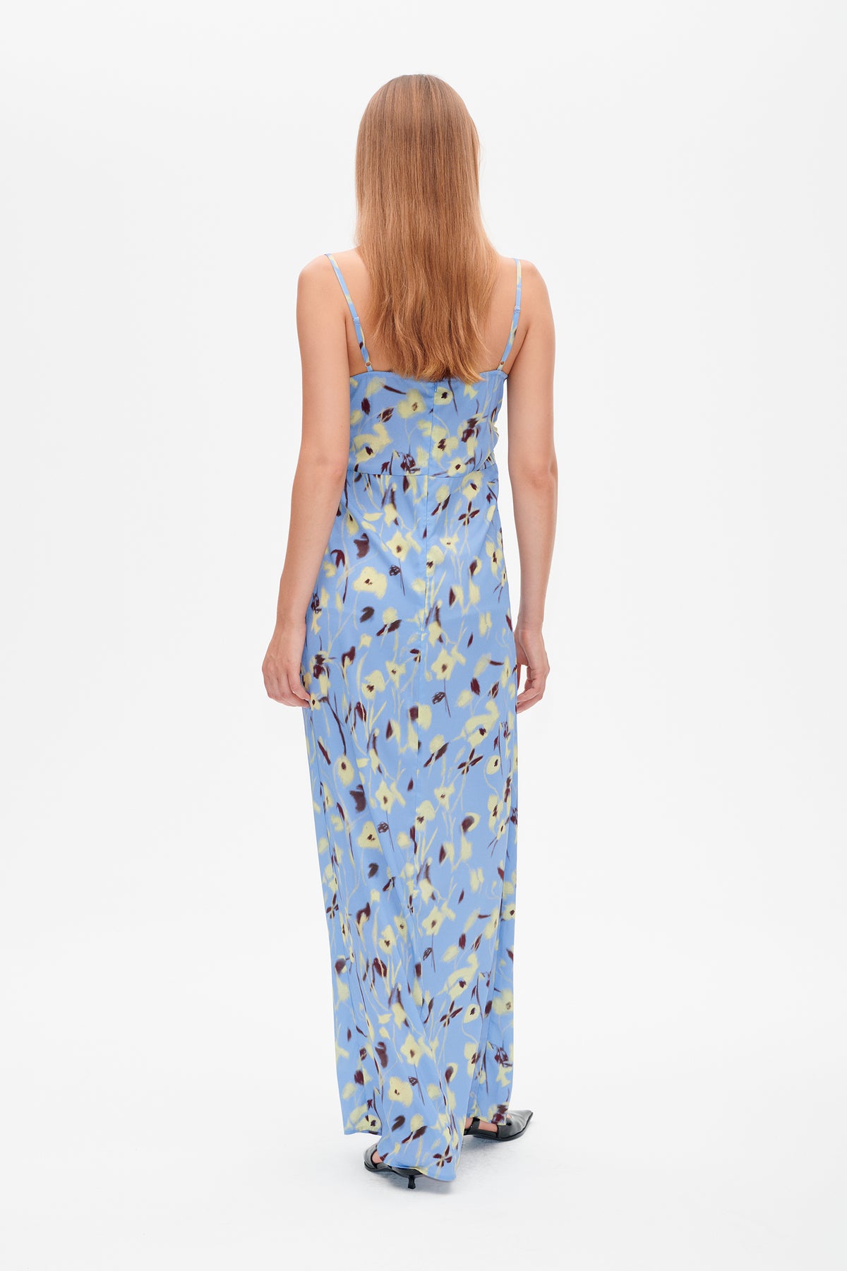 Back view of a long blue spaghetti-strap dress with a yellow and burgundy floral print.