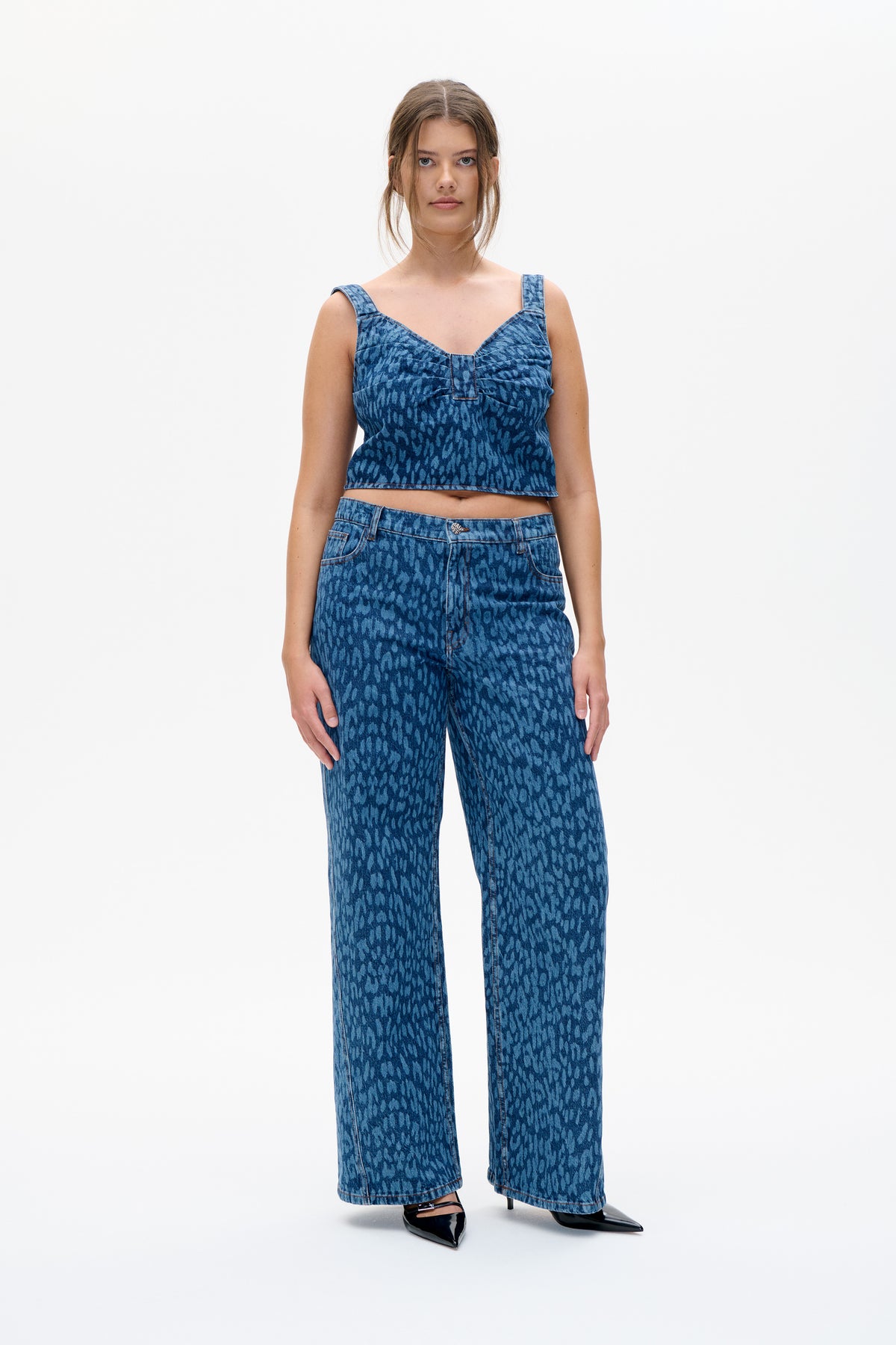 Front view of a model wearing a blue patterned denim crop top with wide straps and matching wide-leg trousers.