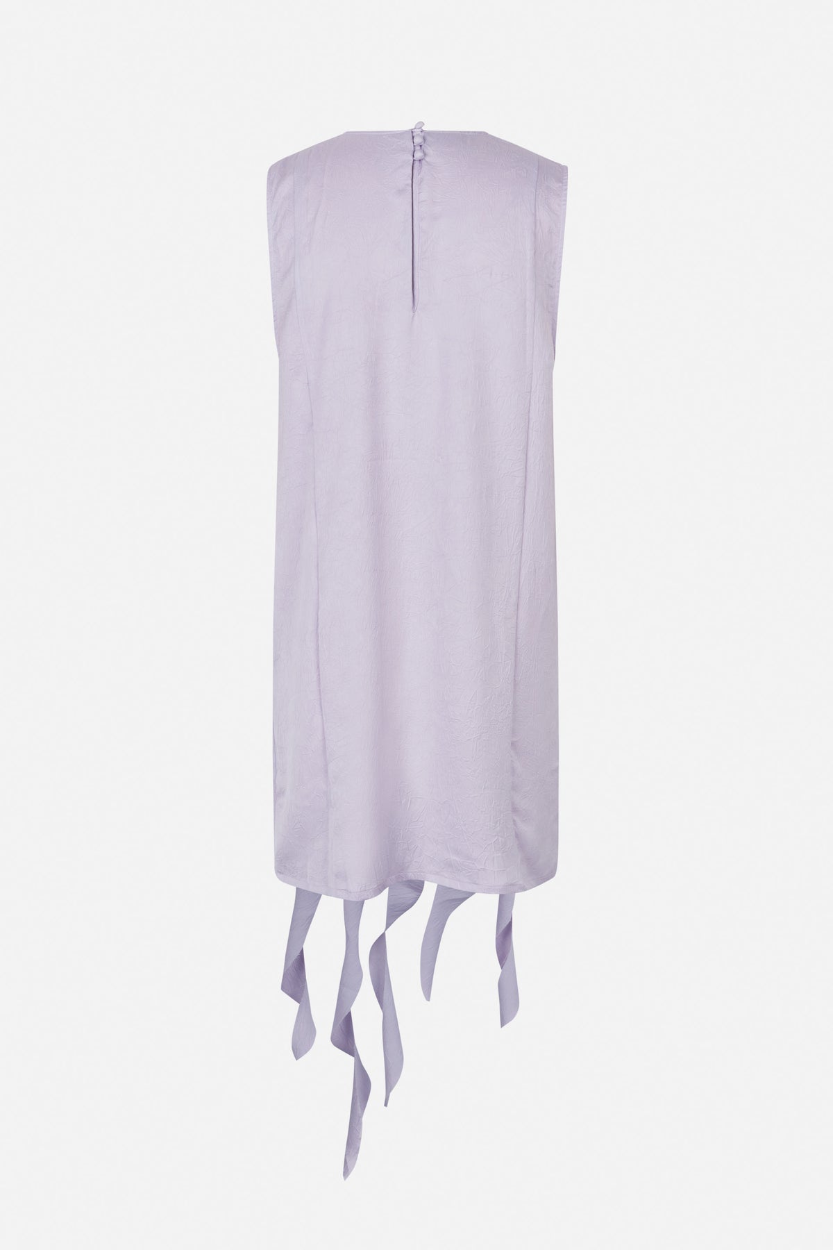 Back view of a pale lavender sleeveless shift dress with crinkled texture, covered buttons and long fabric strips hanging from the hem.