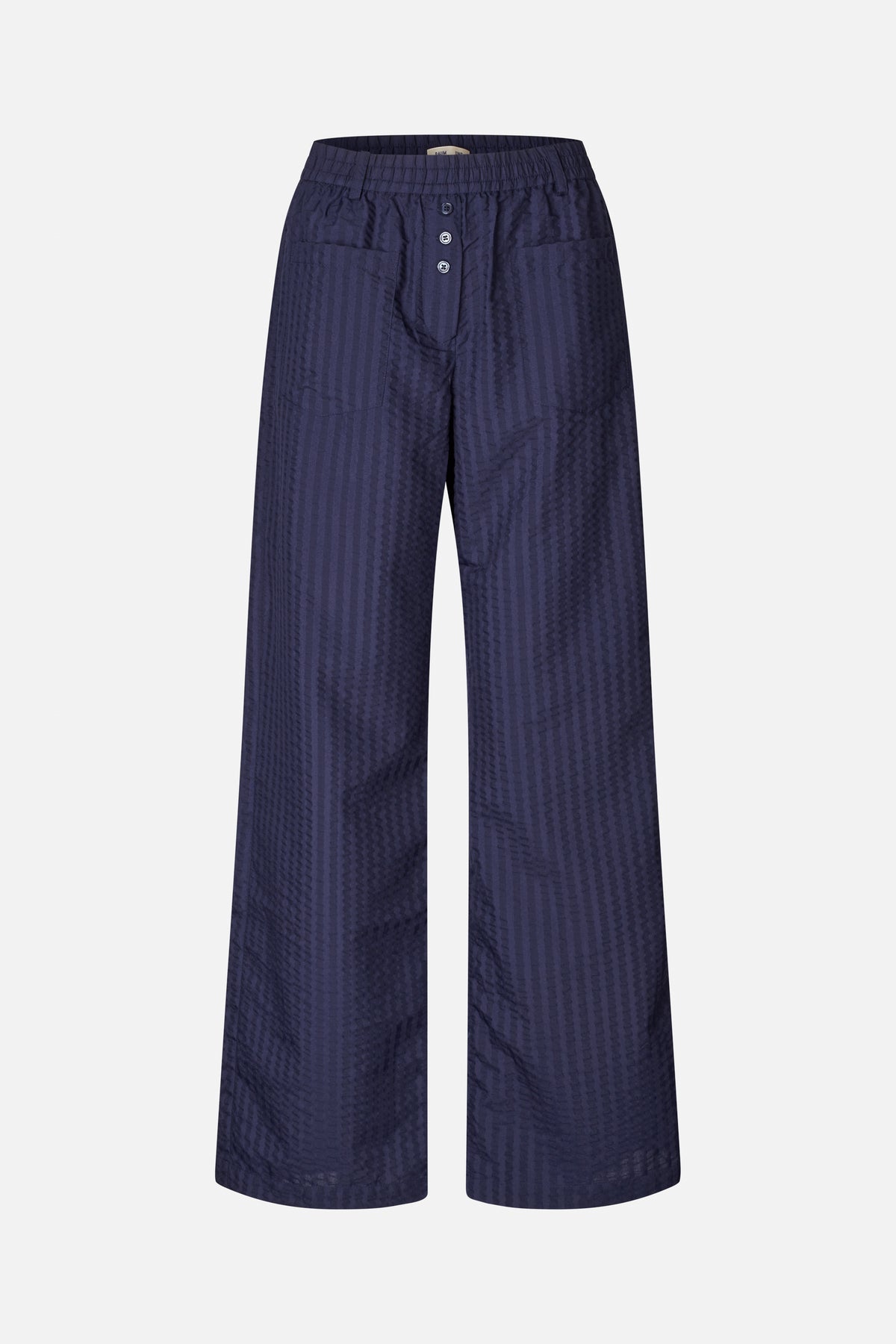 Front view of navy wide-leg trousers with a subtle textured stripe pattern, elastic waistband, button fly and large patch pockets.