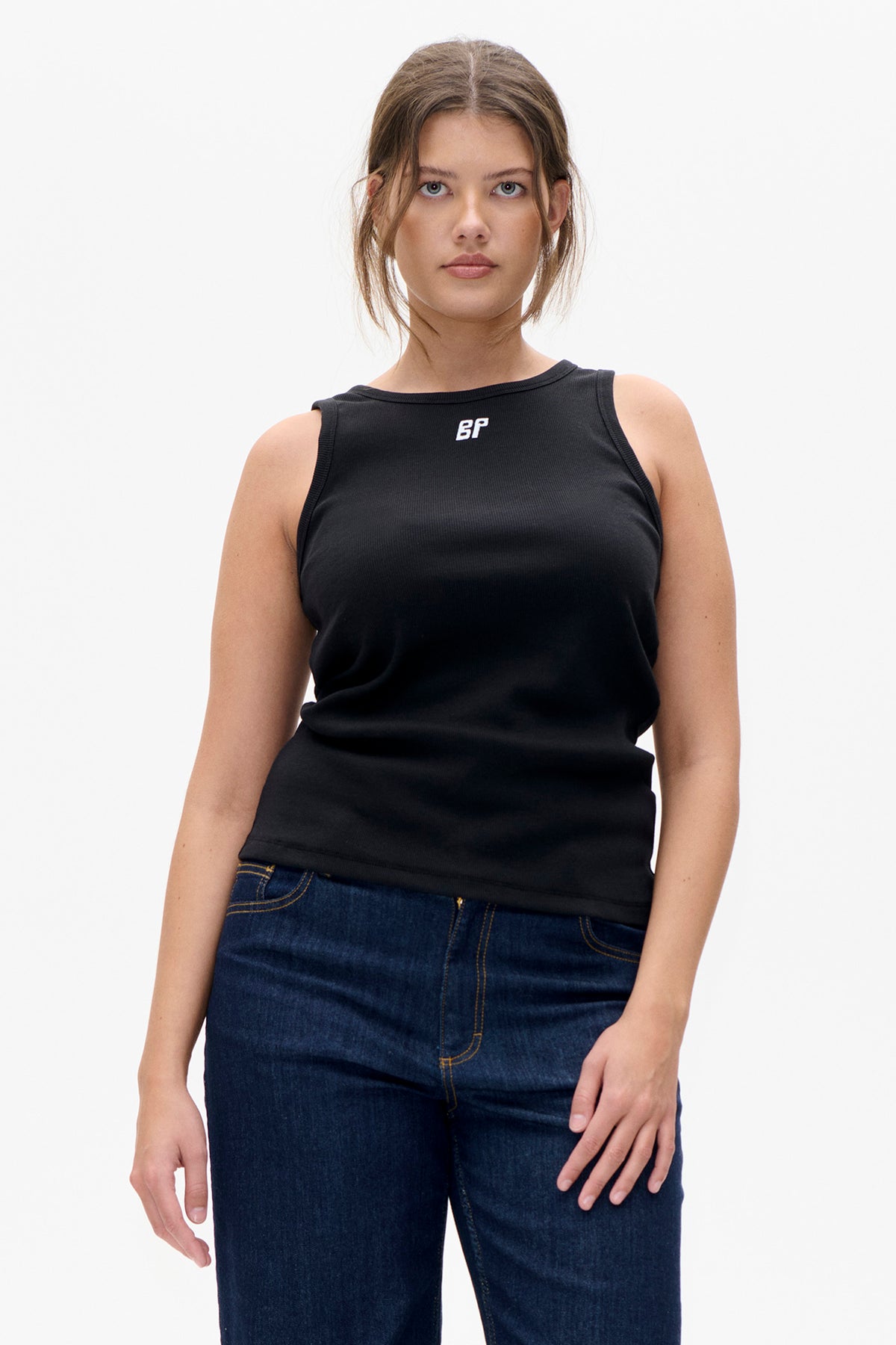 Front view of a model wearing a black sleeveless top with a small white BP logo and dark blue jeans.