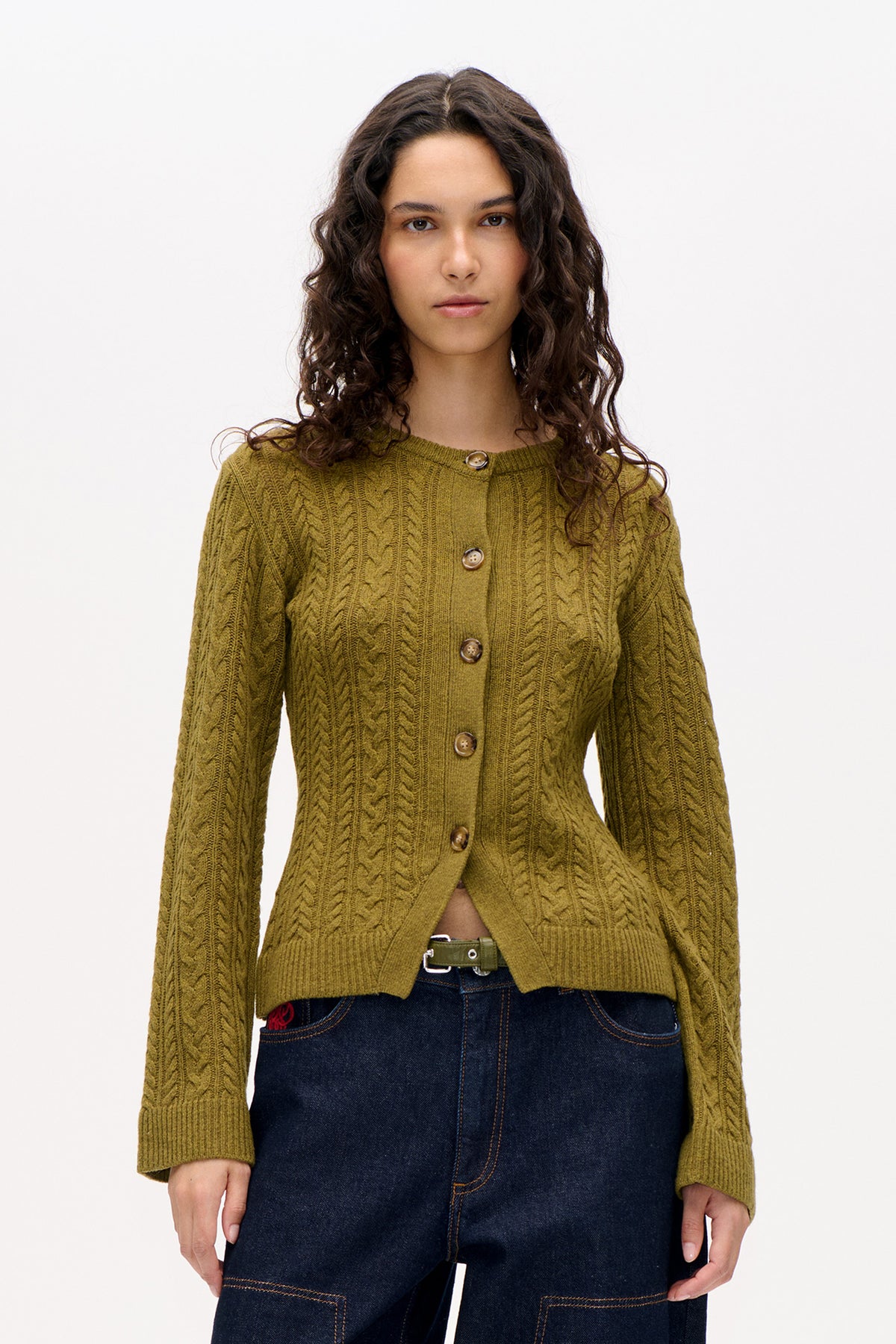 Front view of an olive-green cable-knit cardigan with long sleeves, ribbed edges and brown buttons, worn with dark jeans.