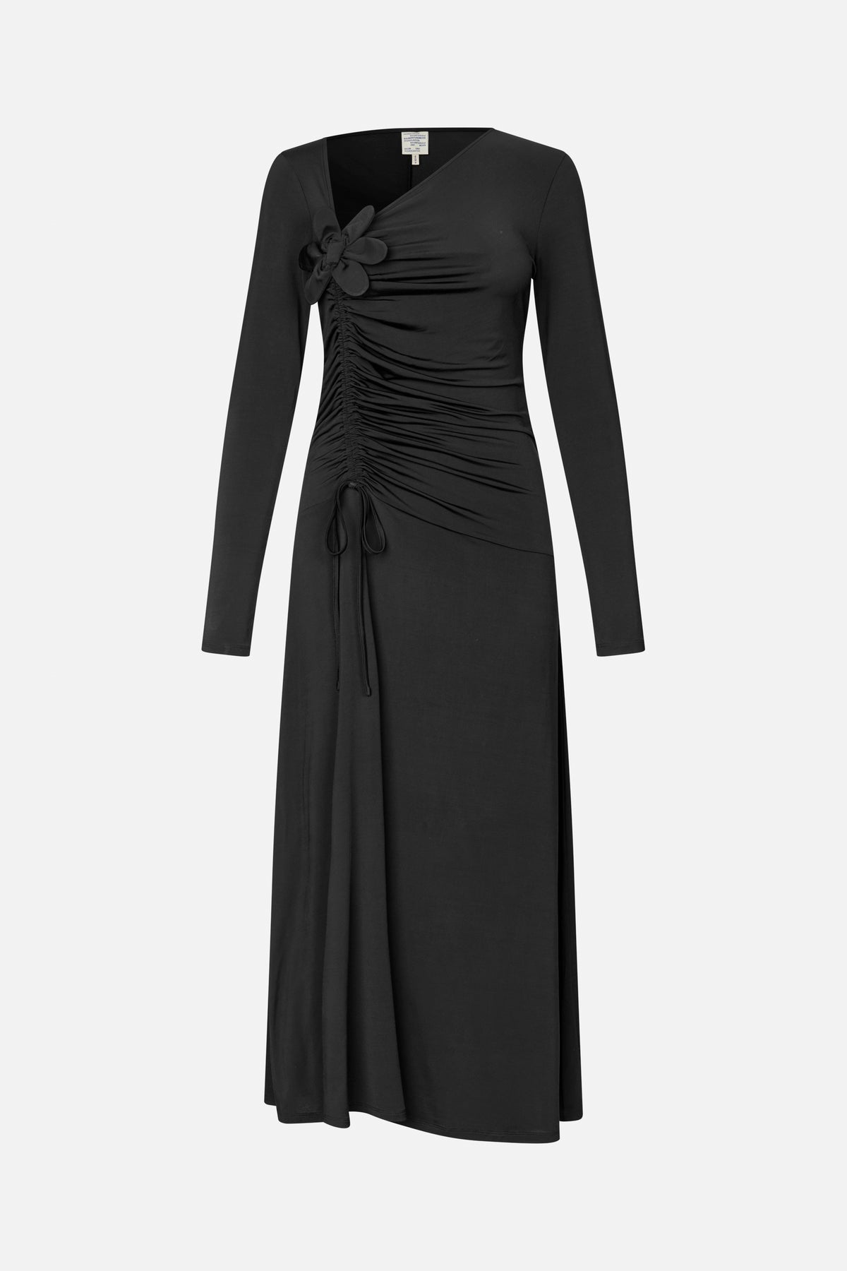 Front view of a black long-sleeved midi dress with an asymmetric neckline, gathered side ruching, tie detail and fabric flower at the shoulder.