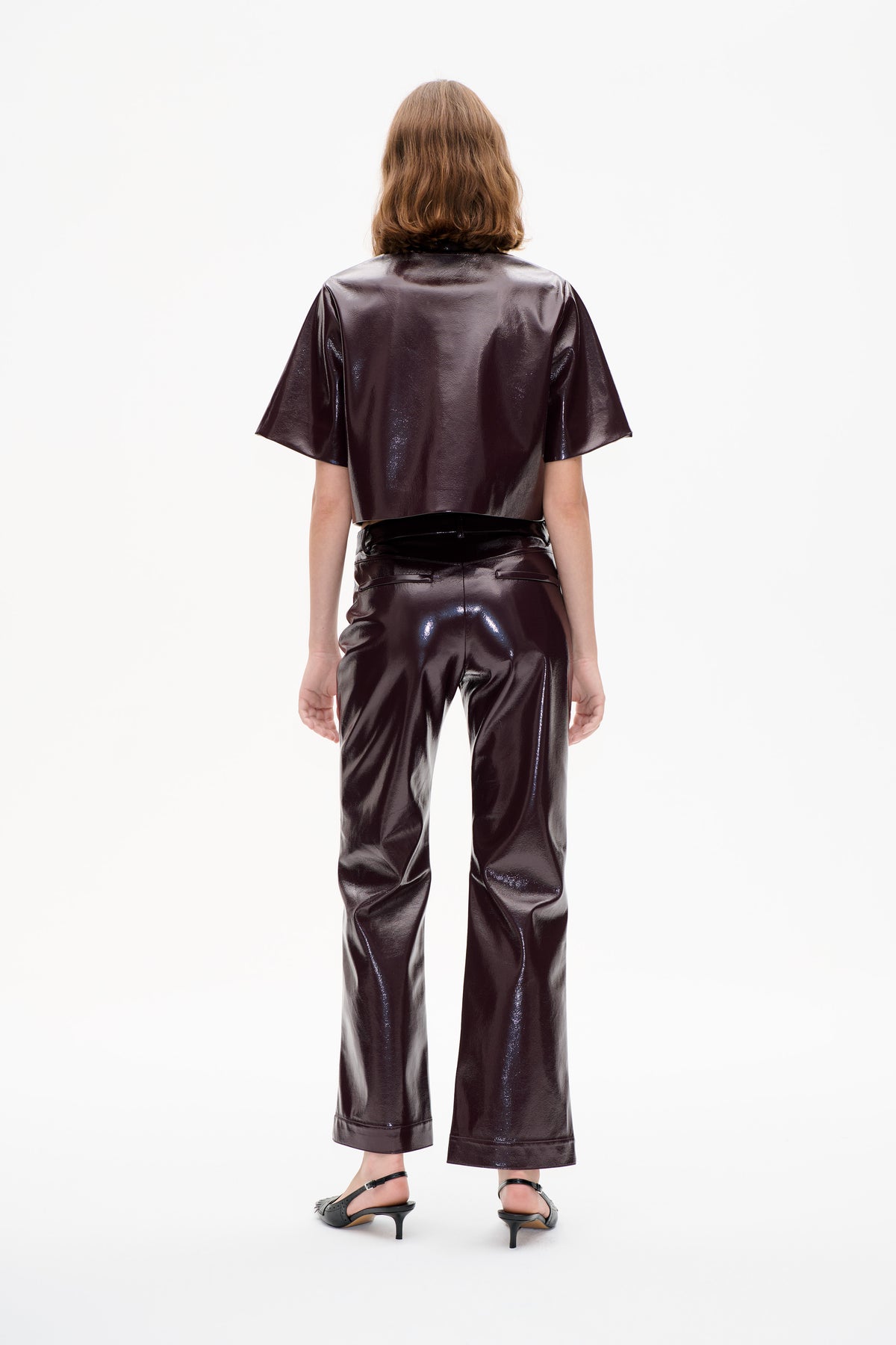 Back view of a model wearing a glossy dark brown short-sleeved top and matching wide-leg trousers.