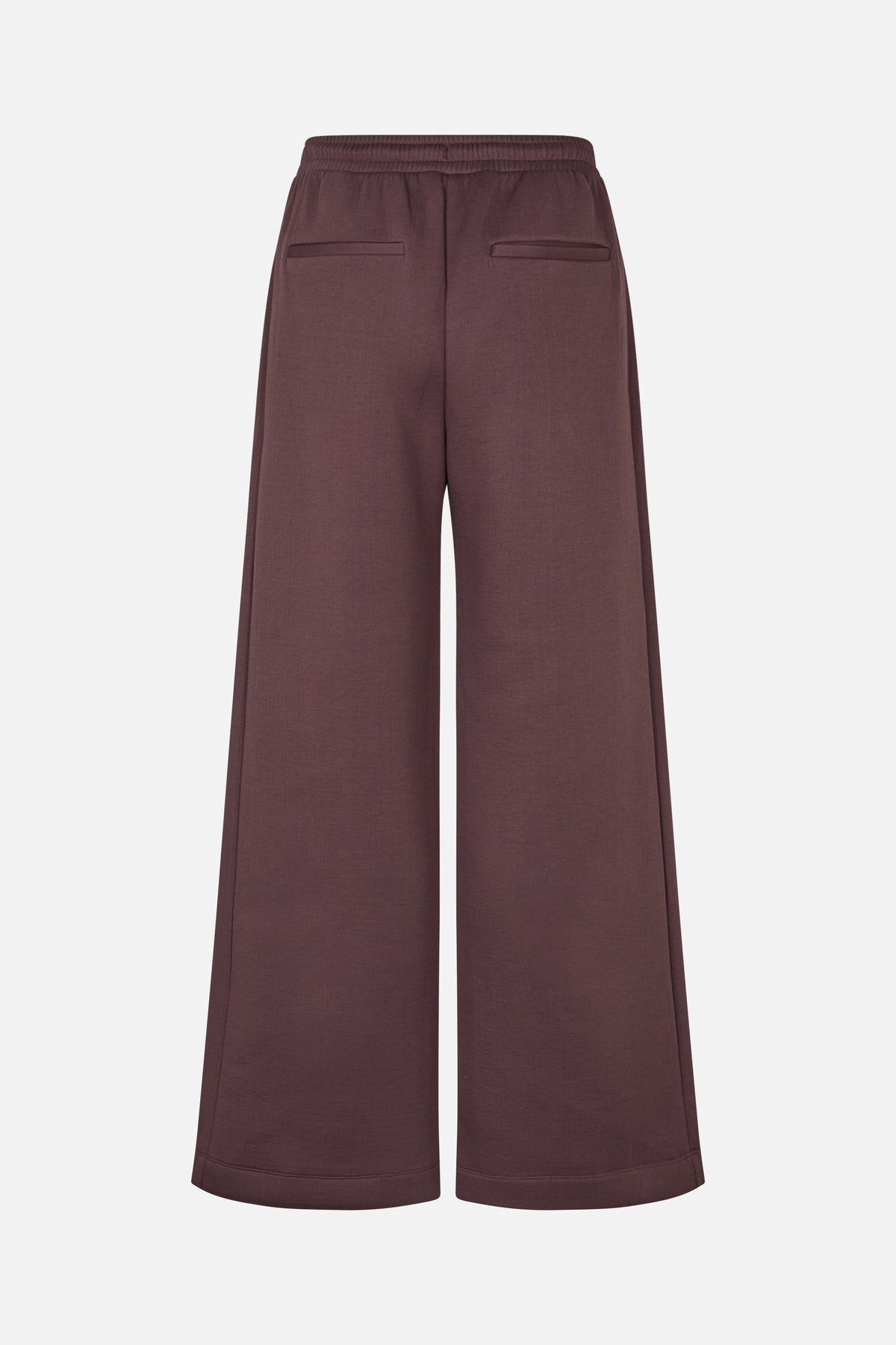 Back view of dark mauve wide-leg trousers with an elasticated waistband and two welt pockets.