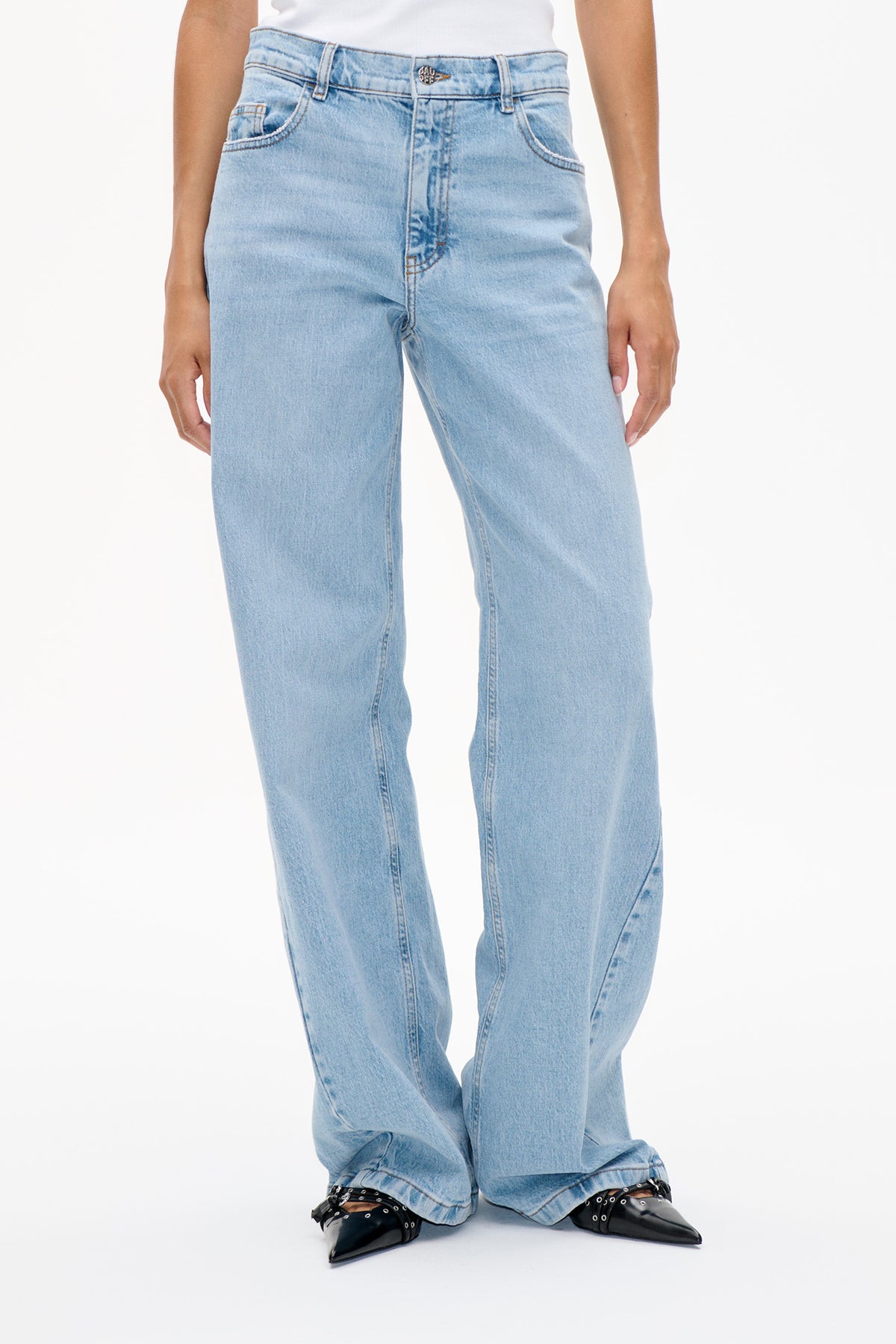 Front detail of light-wash blue wide-leg jeans with a button waistband, belt loops and curved front pockets.