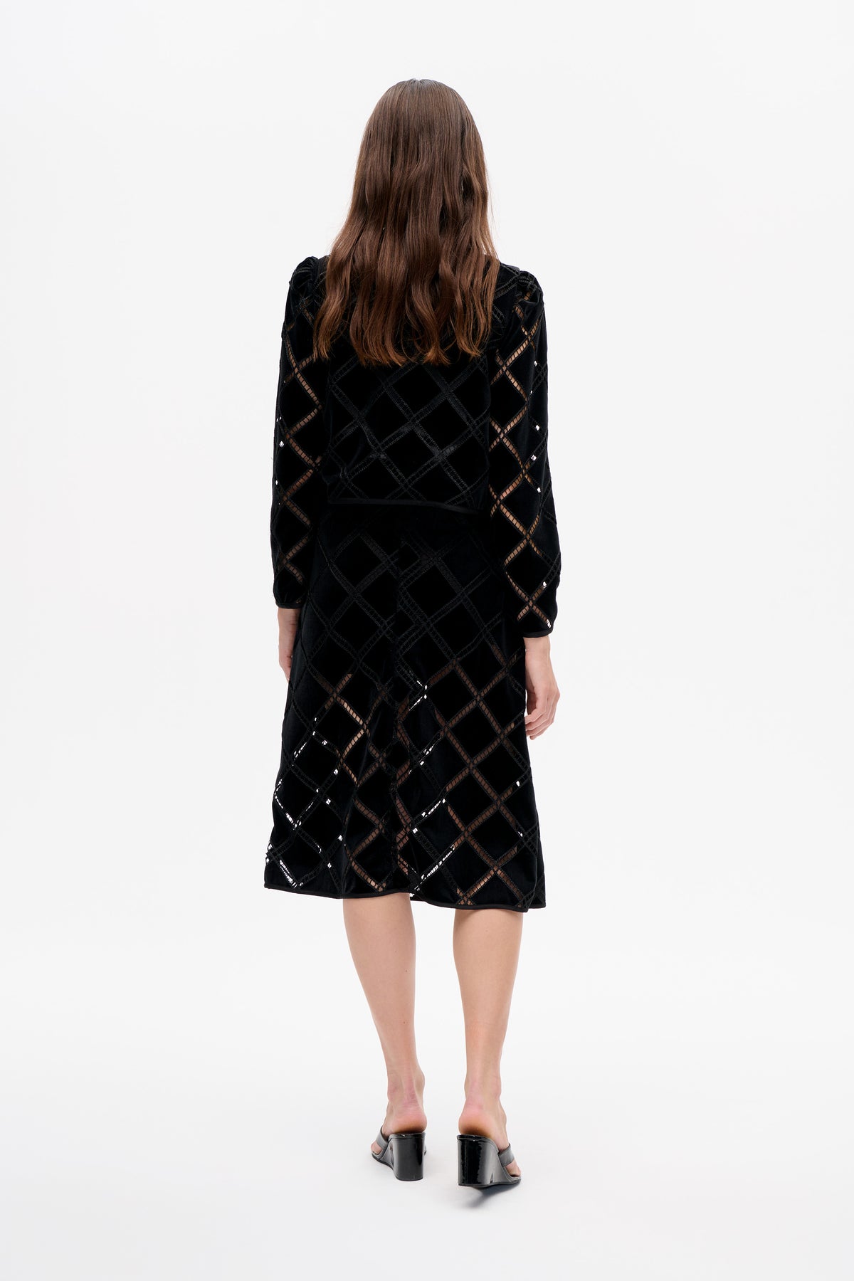 Back view of a black knee-length dress with short sleeves, geometric diamond lattice cutouts and subtle glossy accents.