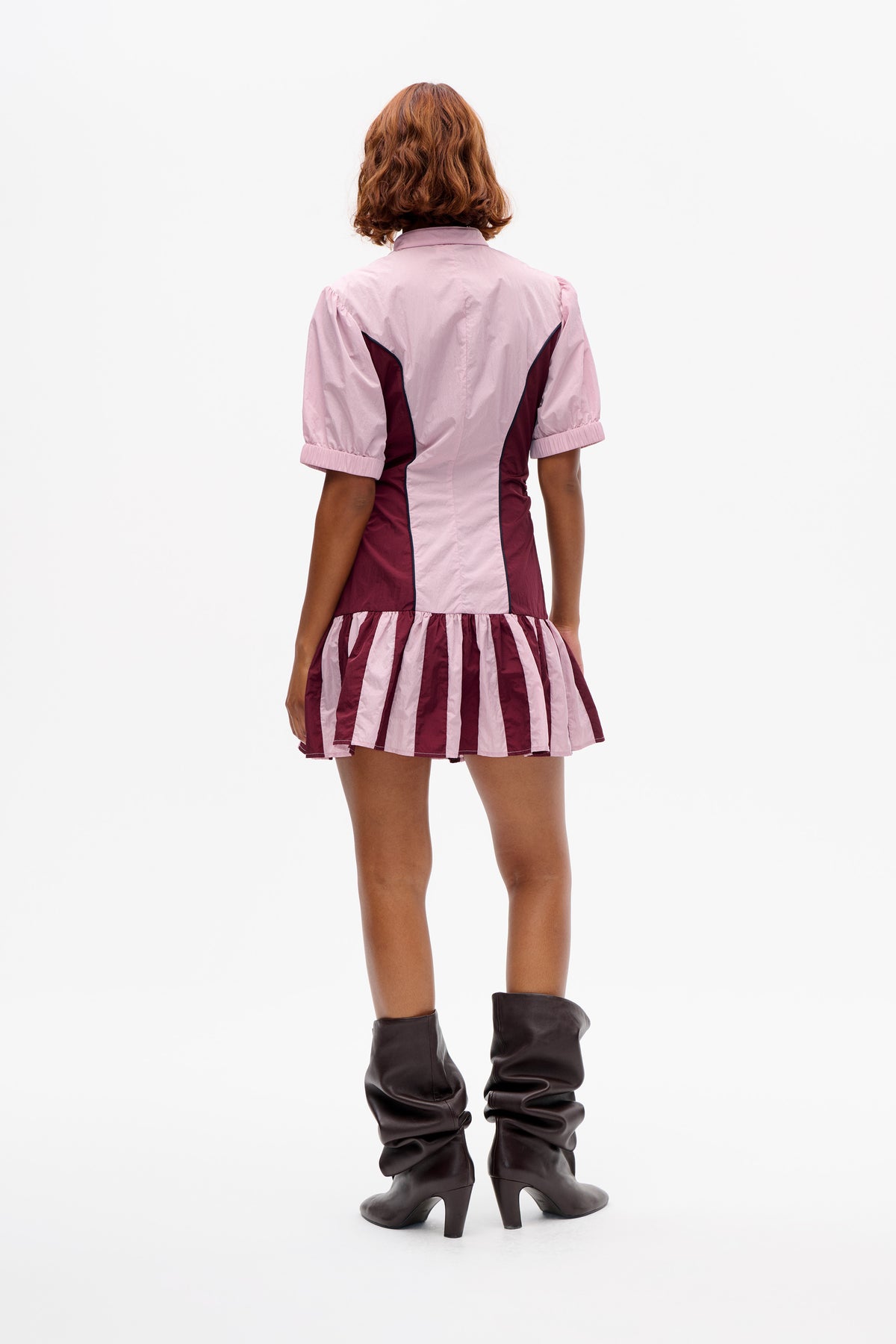 Back view of a short-sleeved dress with a pink bodice, burgundy side panels and a gathered pink-and-burgundy striped skirt.