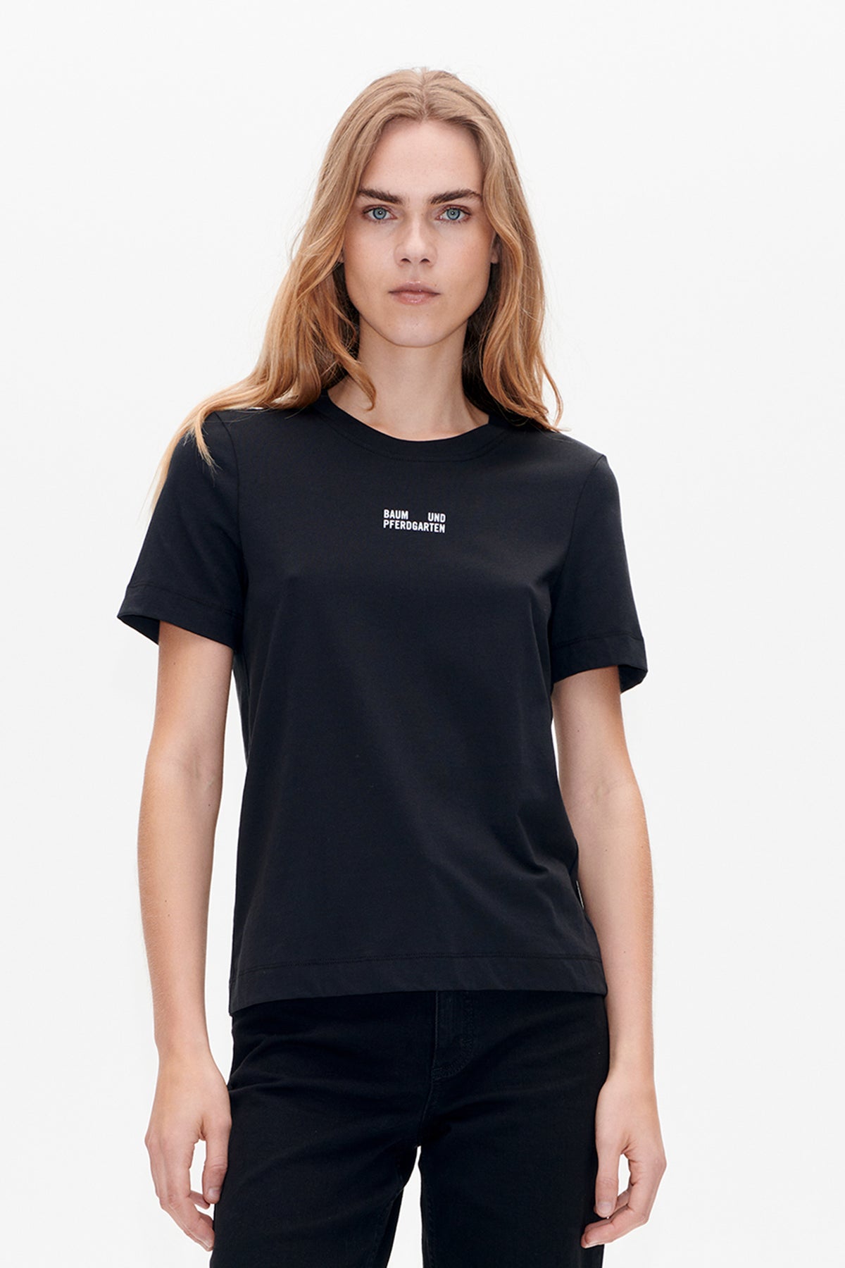 Front view of a black short-sleeve crew-neck T-shirt with a small white Baum und Pferdgarten logo on the chest.