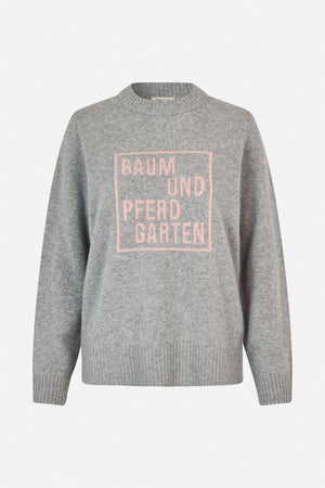 Front view of a marled grey knit sweater with ribbed trim and a pink Baum und Pferdgarten logo.