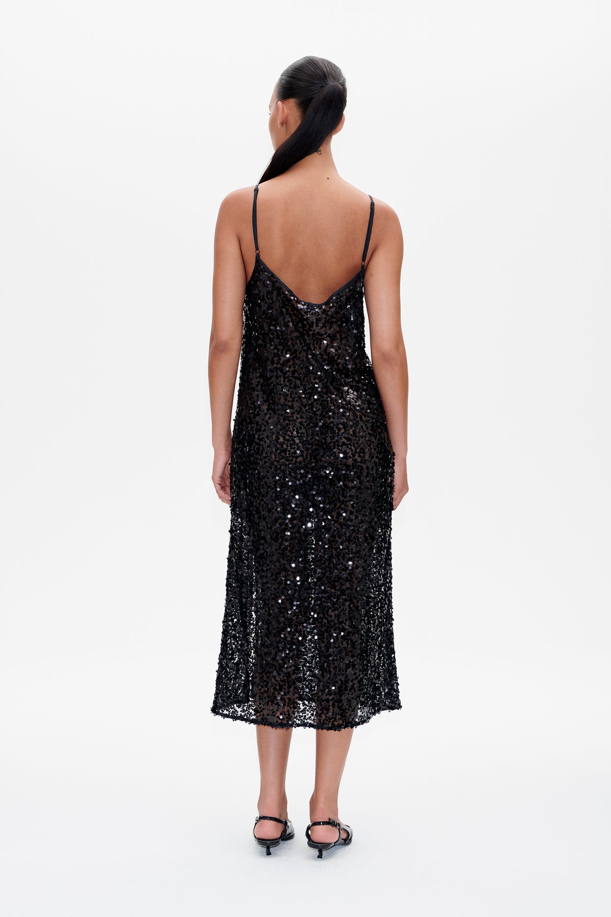Back view of a black spaghetti-strap midi dress covered in reflective sequins.