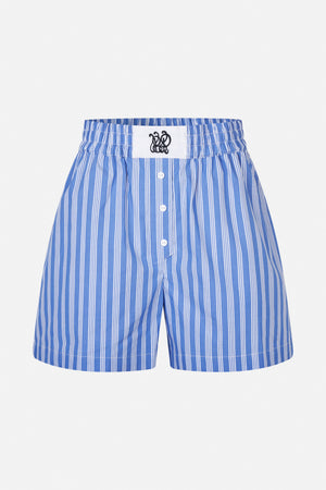 Front view of blue shorts with irregular white vertical stripes, an elasticated waistband, button fly and embroidered patch.