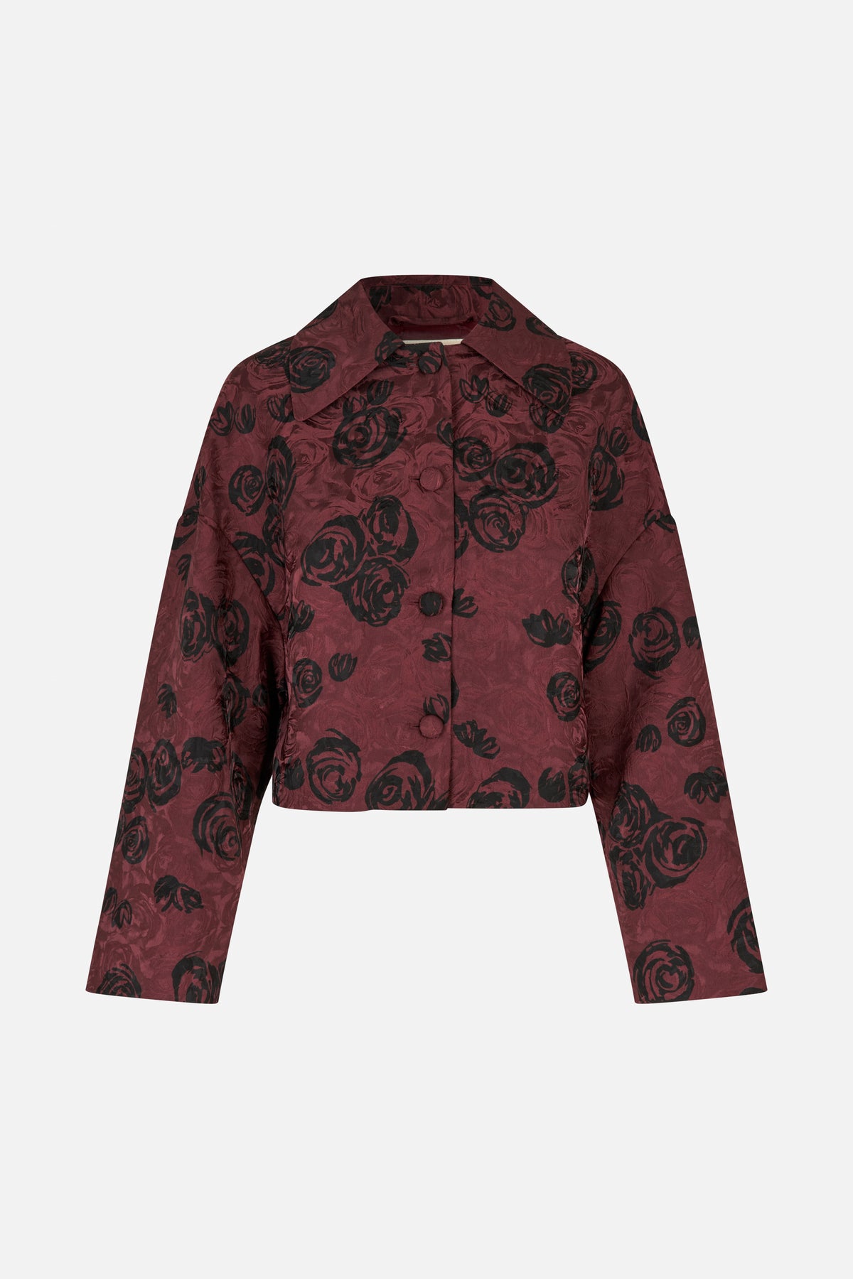 Front view of a cropped burgundy jacket with black rose print, a wide collar, long sleeves and covered buttons.