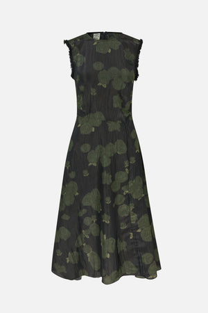 Robe longue sans manches, fond sombre avec imprimé floral vert atténué, taille cintrée, jupe évasée et franges aux emmanchures.
