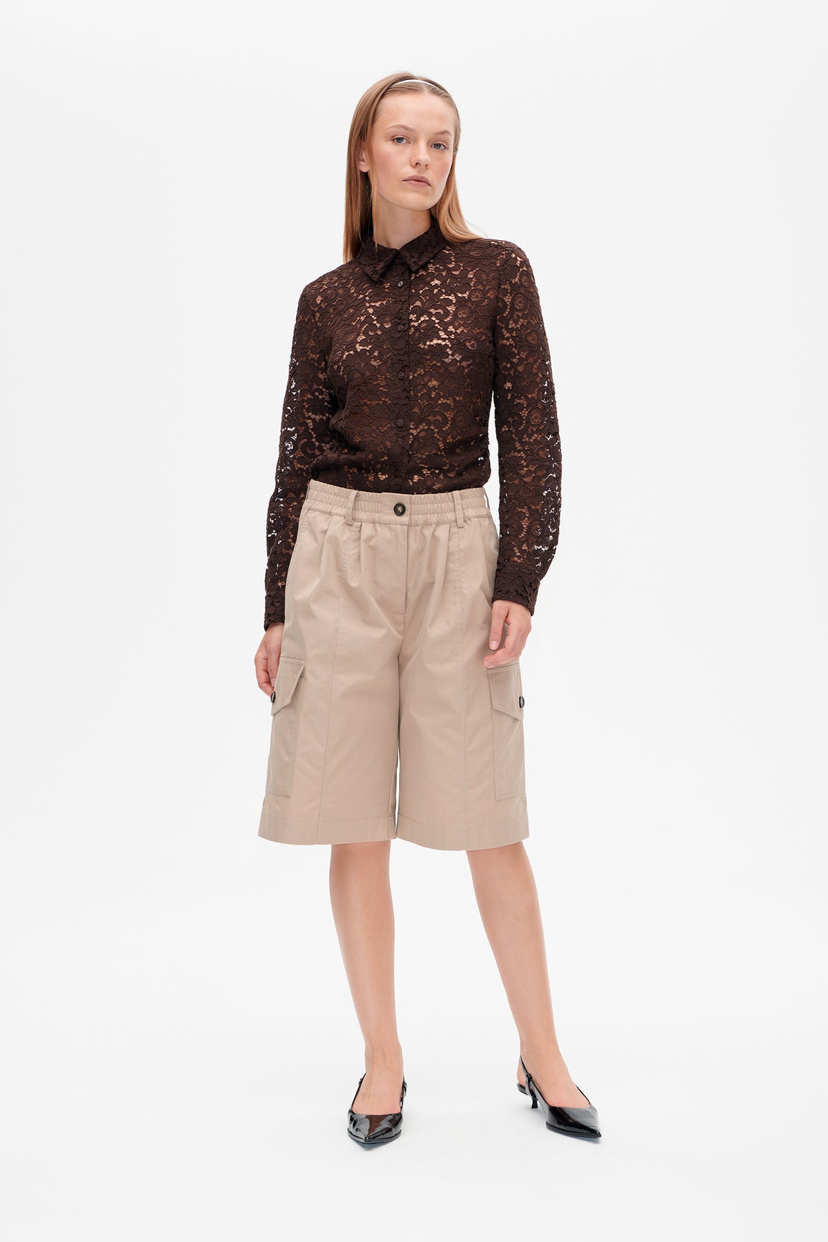 Model wearing a dark brown floral lace button-up shirt with beige knee-length cargo shorts.