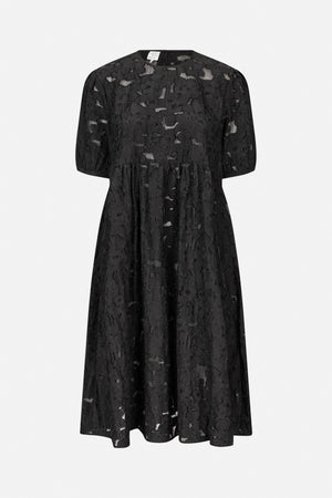 Front view of a black dress with short puff sleeves, a gathered waist, and textured floral fabric with sheer cutout details.