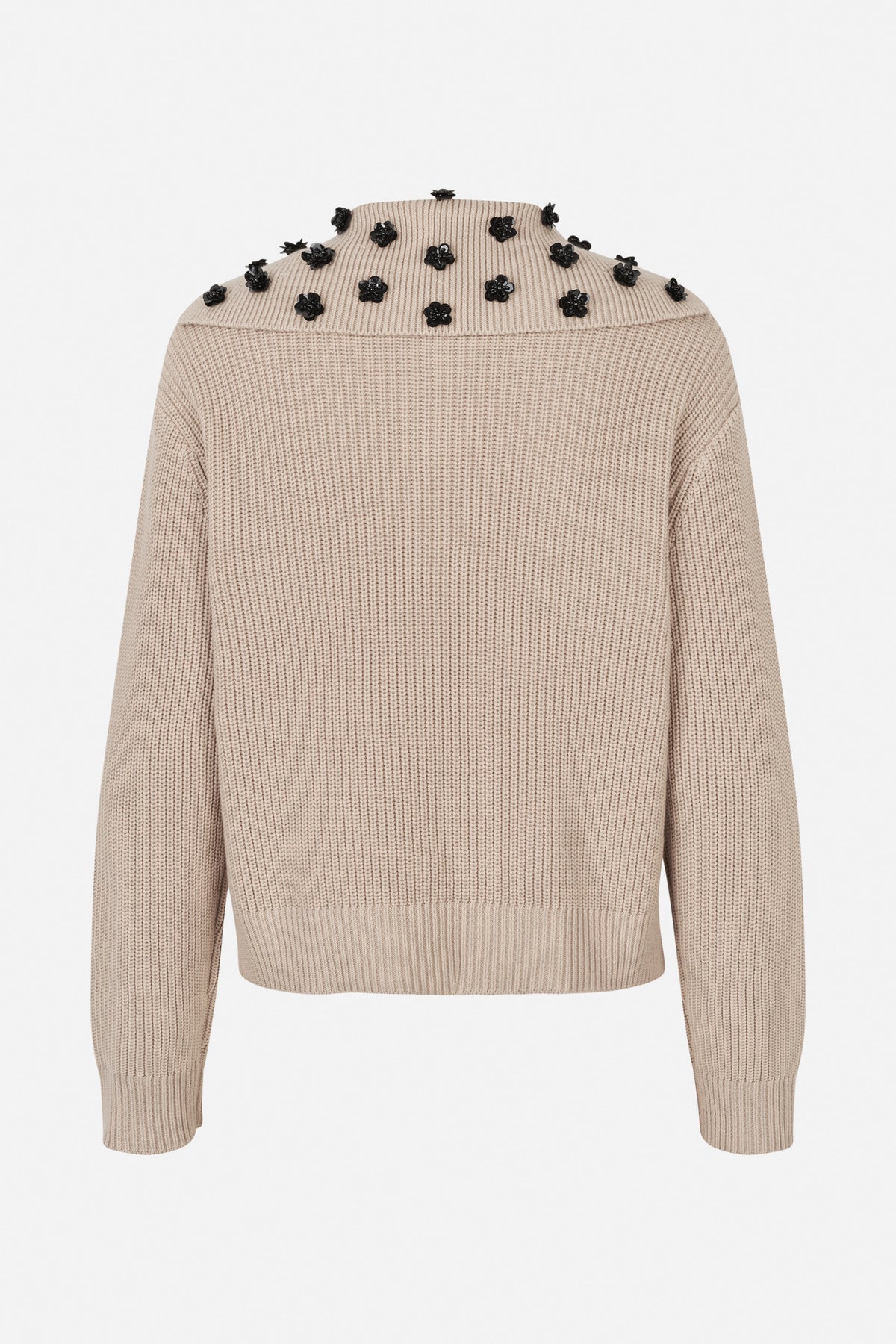 Front view of a taupe rib-knit sweater with a high neck and black flower embellishments across the shoulders and upper chest.