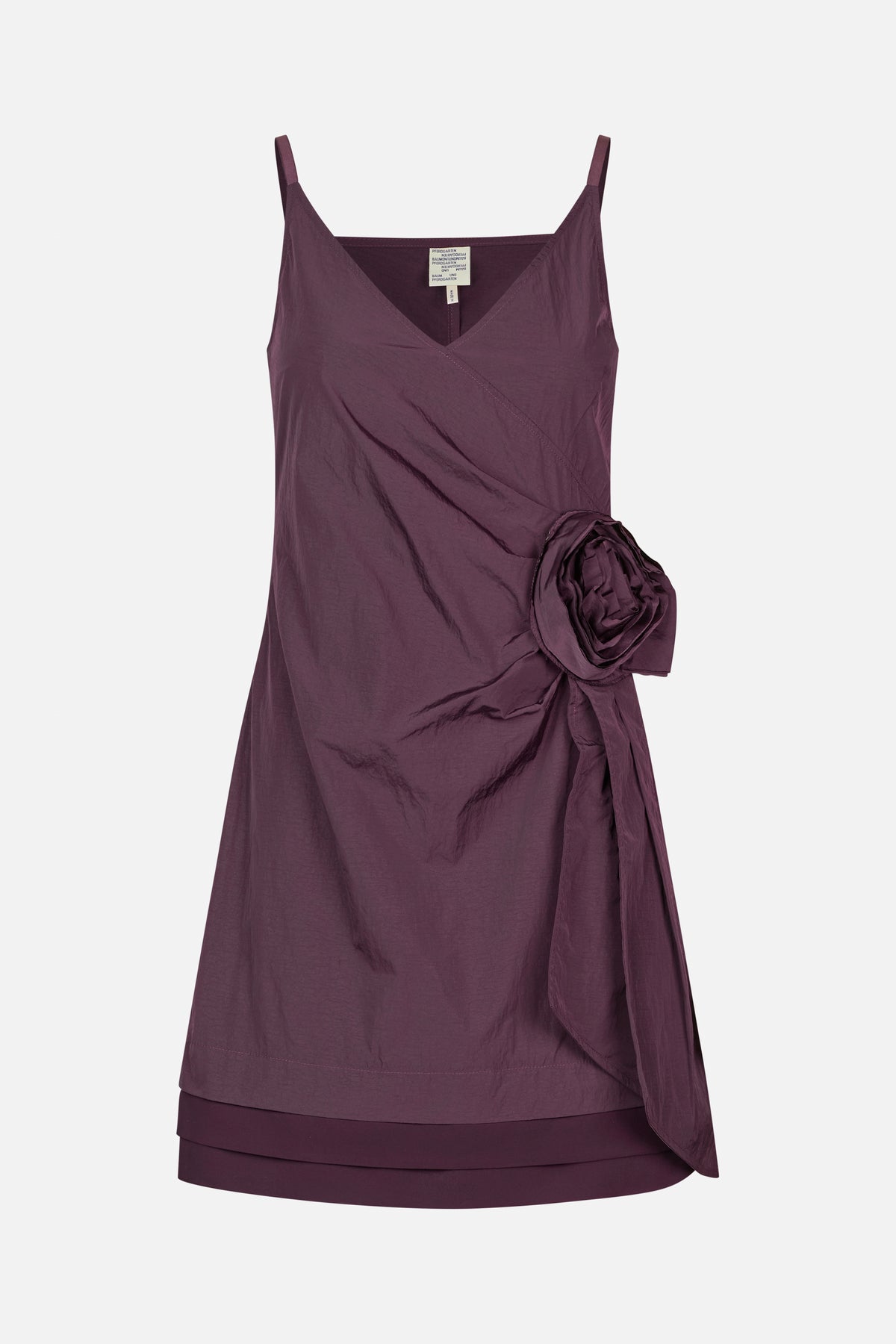 Front view of a plum sleeveless dress with thin straps, a V-neckline, and a large fabric flower detail at the side.