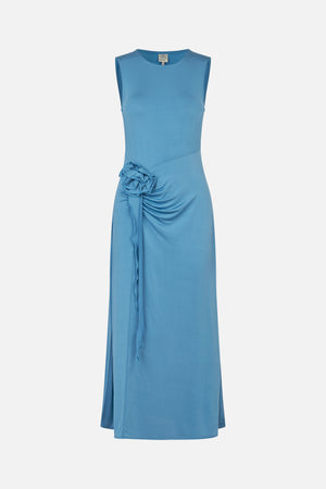 Front view of a sleeveless blue midi dress with a round neckline, diagonal waist seam and gathered ruffle detail at the hip.