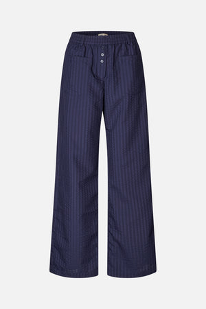 Front view of navy wide-leg trousers with a subtle textured stripe pattern, elastic waistband, button fly and large patch pockets.