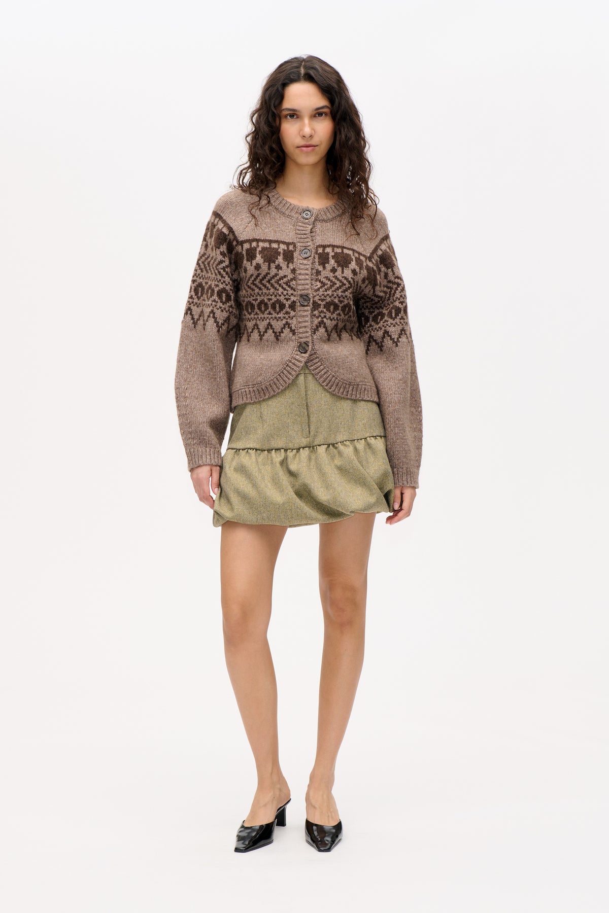 Front view of a taupe button-front knit cardigan with dark brown geometric pattern, styled over a muted olive short skirt.