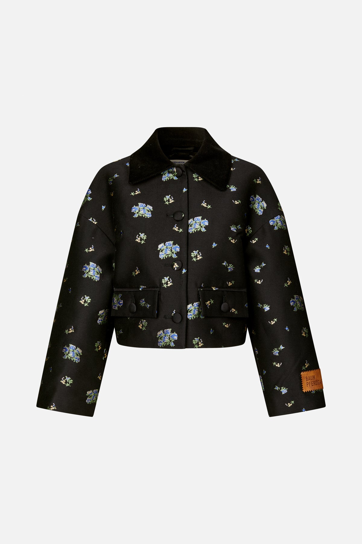 Front view of a black cropped jacket with blue and green floral motifs, a wide corduroy collar, covered buttons and flap pockets.