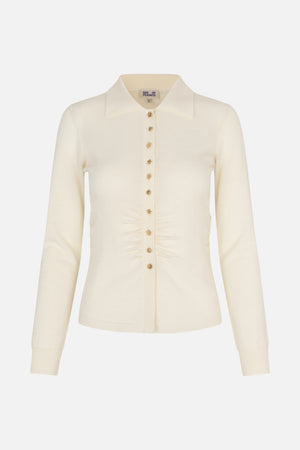 Front view of an ivory long-sleeved knit cardigan with a pointed collar, ornate gold buttons and ruching at the waist.