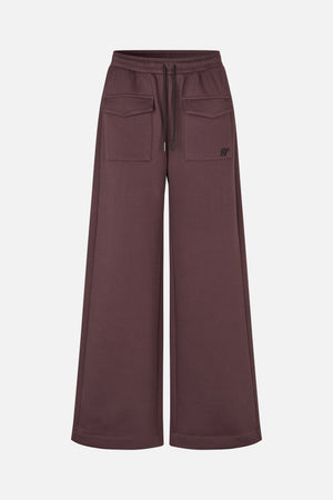 Front view of plum-brown wide-leg trousers with an elastic drawstring waist, large flap pockets and a small logo.