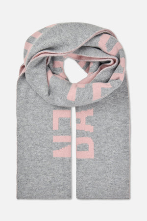 Knitted grey scarf with large pink geometric blocks, folded to show its long ends and stitched edges.