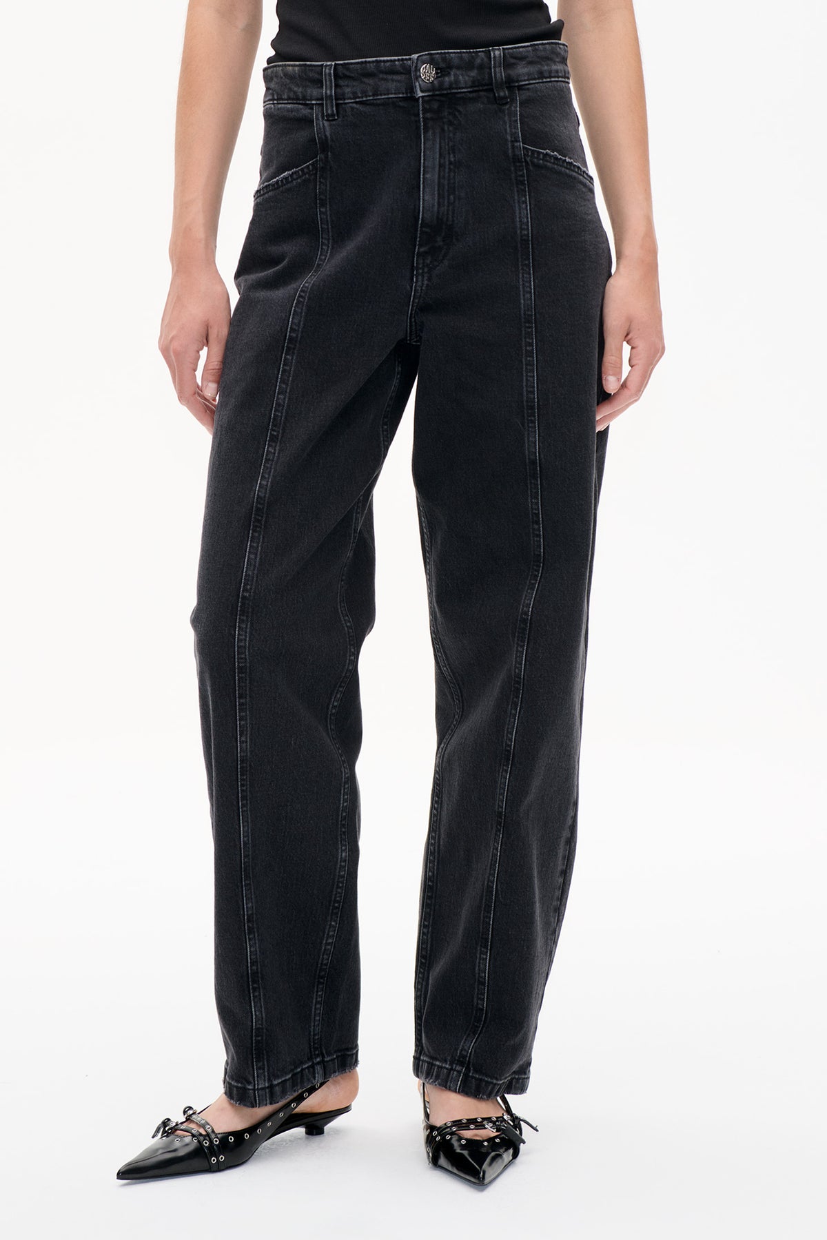 Front detail of charcoal-black washed jeans with contrast seams, curved pockets, belt loops and gathered ankle cuffs.