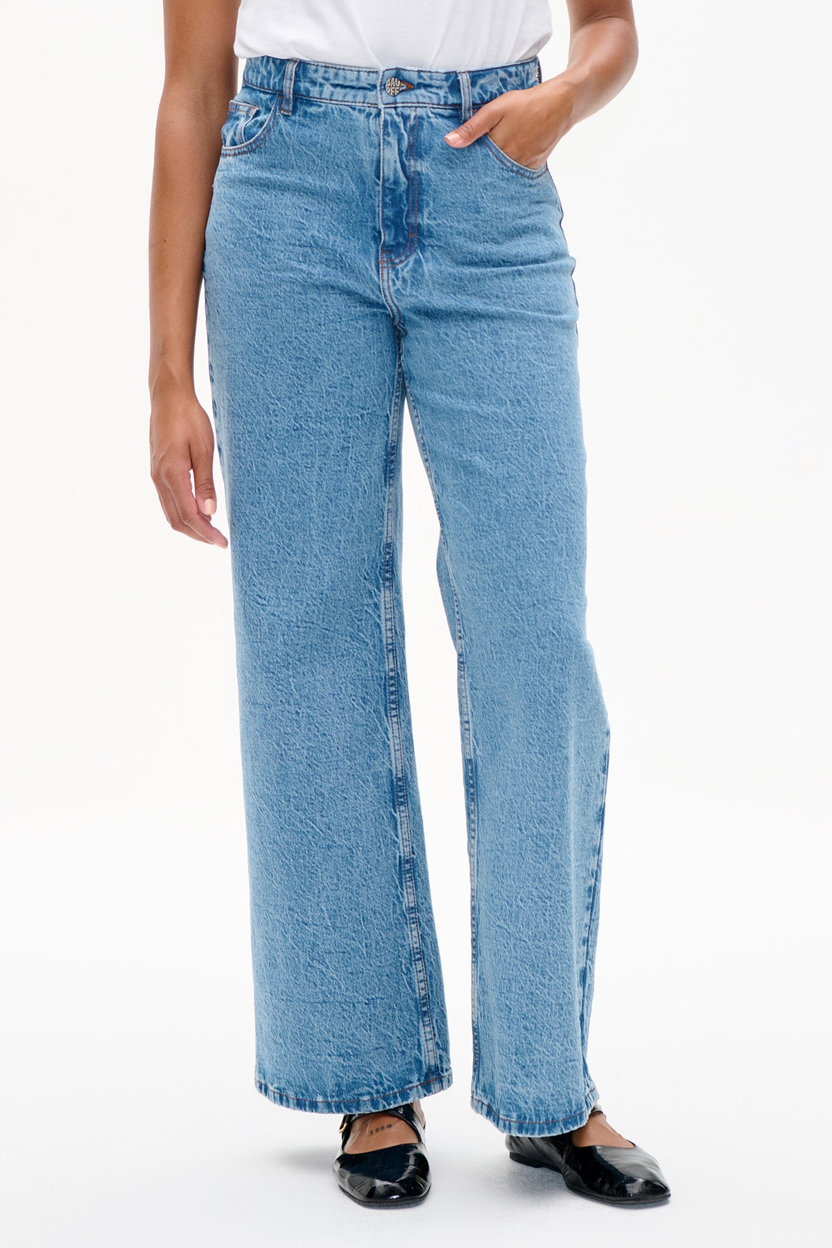 Front detail of light blue acid-wash wide-leg jeans with a high waist, button closure and front pockets.