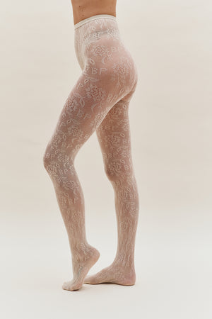 Model wearing sheer ivory tights with an all-over floral lace pattern, shown from waist to feet.